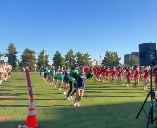 Rows of cheer and pom teams on the lawn outside State Farm Stadium on Cardinals game day, October 2025